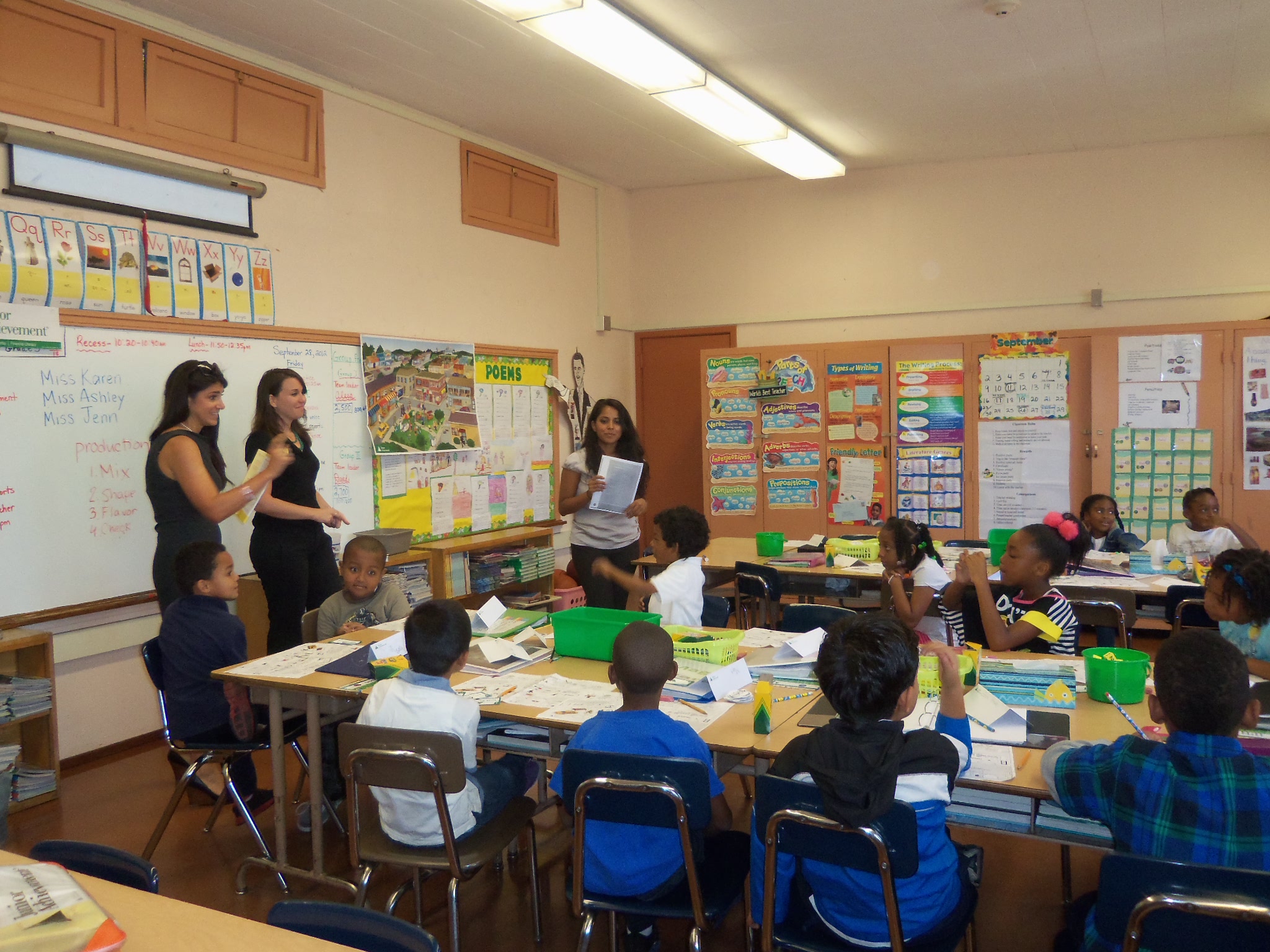 children and adults in a classroom playing with toys