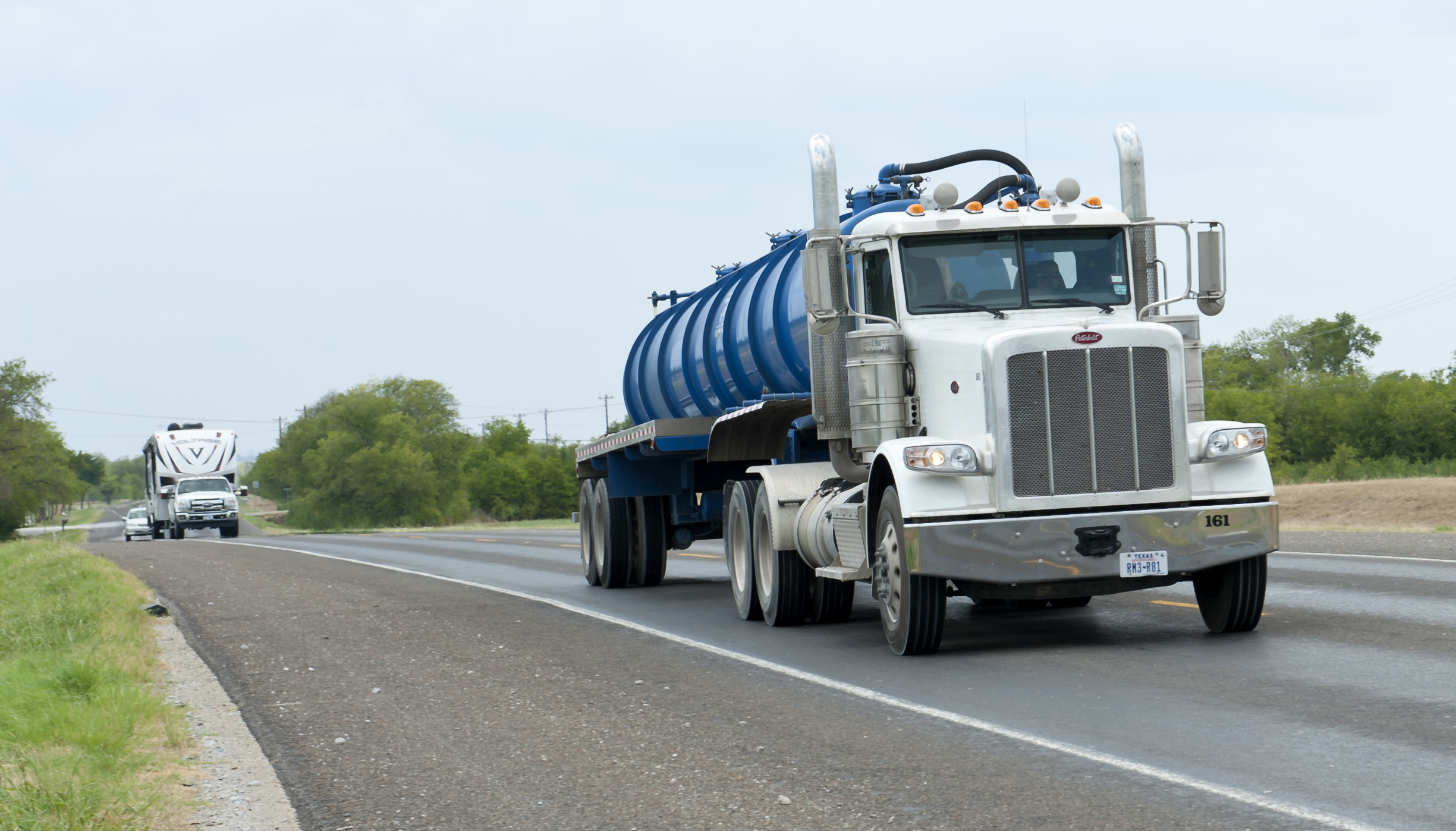 a large blue truck driving down the road