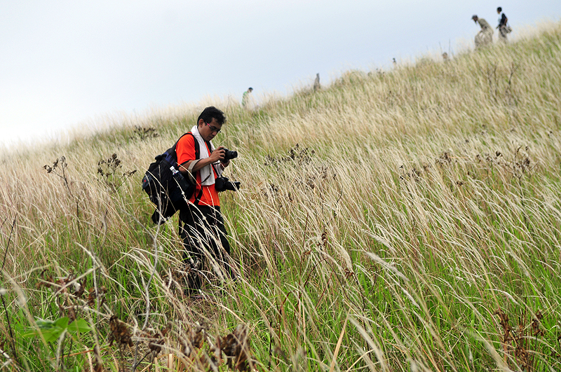 a man standing in a field with his phone