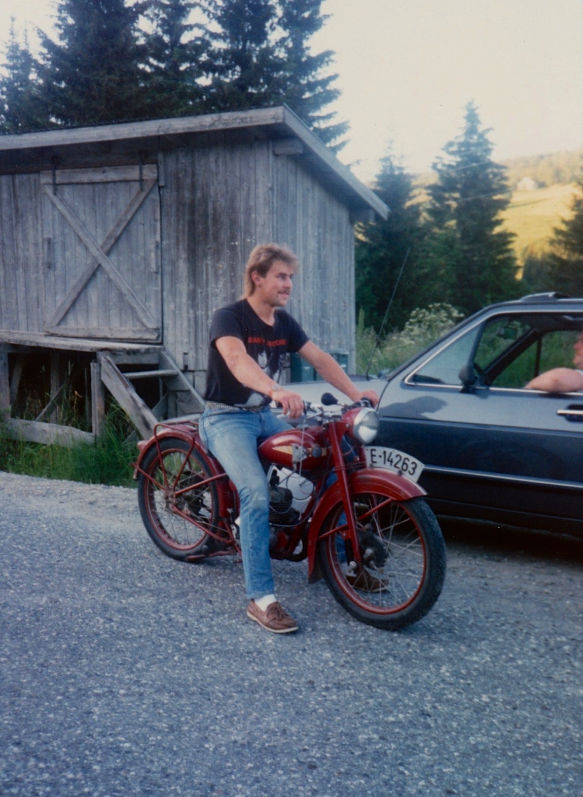 a man in a black shirt is on a motorcycle