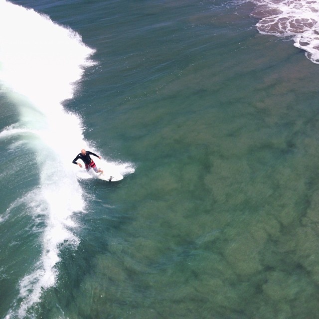 an aerial view of a man surfing in the ocean