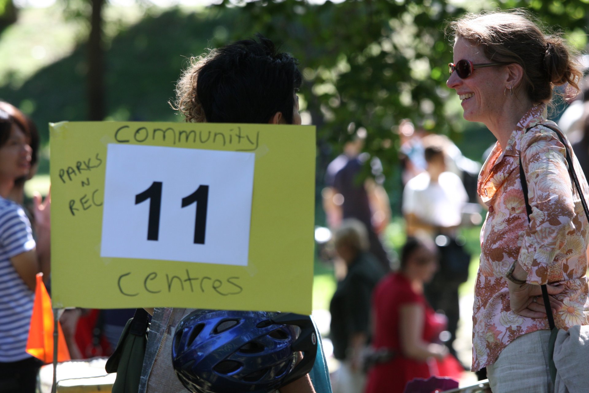 two women standing in a park holding up signs