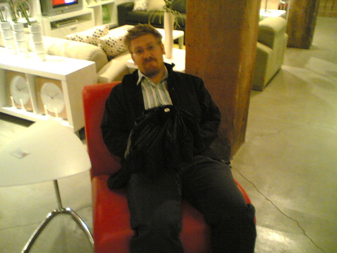 a man sitting on top of a red chair