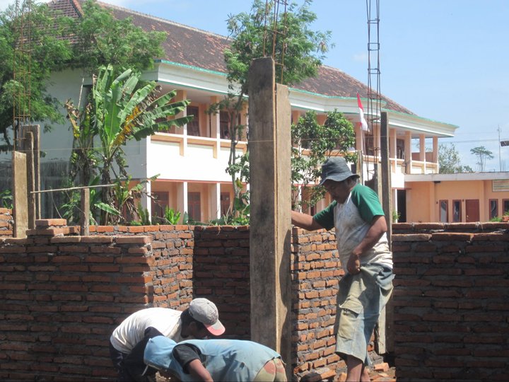 a couple of men working on a wall