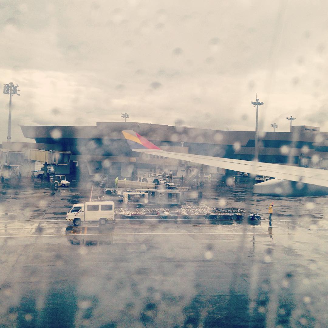 airplane sitting at the airport with rain outside