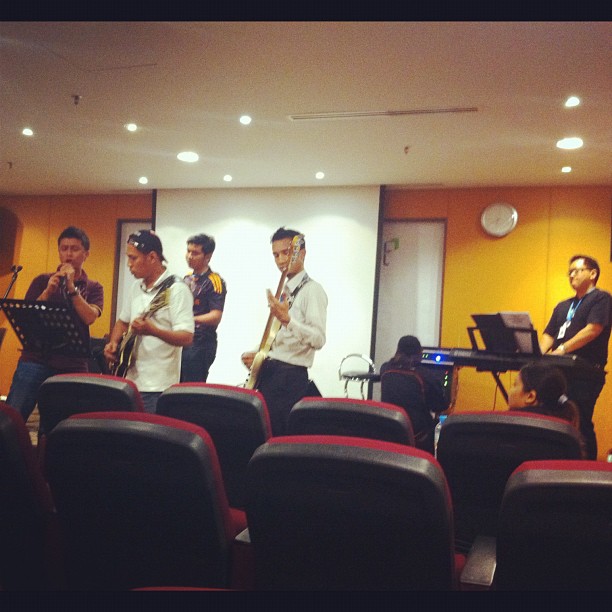 a group of men playing instruments in a meeting room