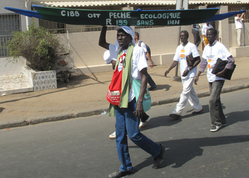 a man carrying a sign over his head down a street