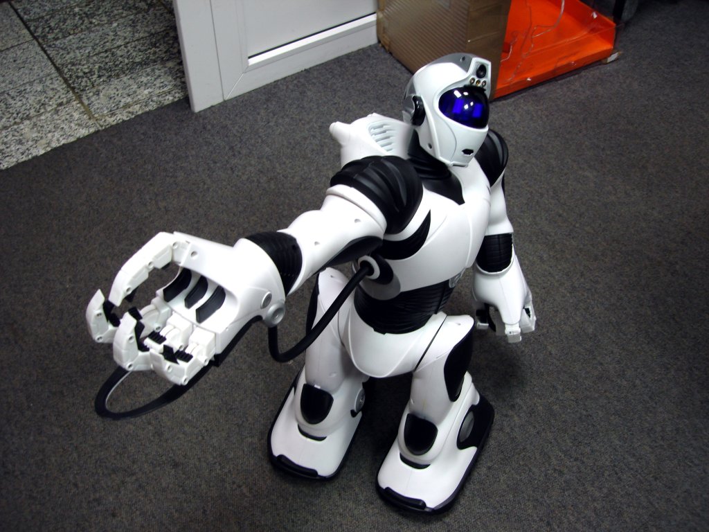 a robot standing next to a chair with it's legs stretched out