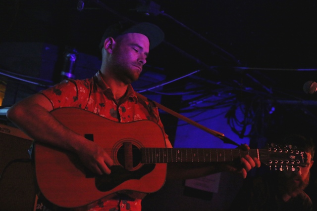 a person holding a guitar while standing in front of a microphone