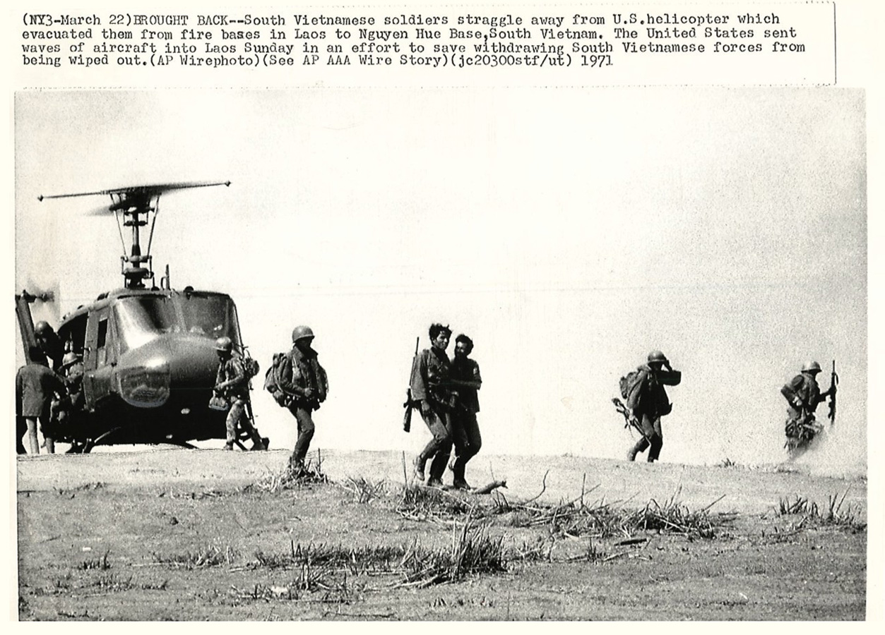 black and white pograph of soldiers by helicopter