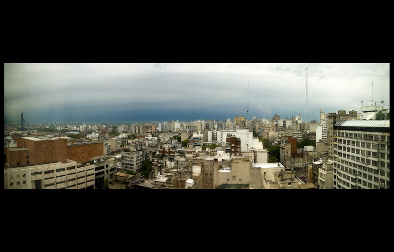 looking down on a cityscape with tall buildings and cloudy sky