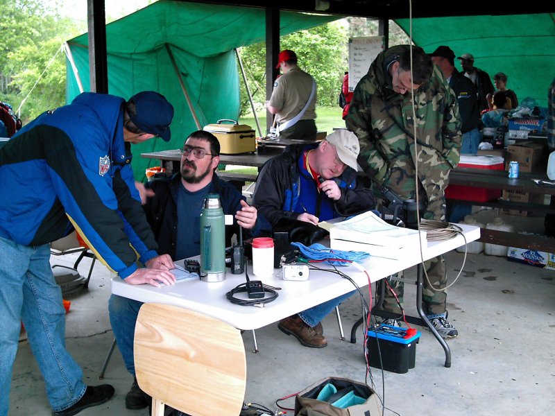 a group of people standing around each other near a table