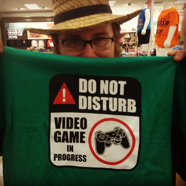 a man in a store holding a video game shirt