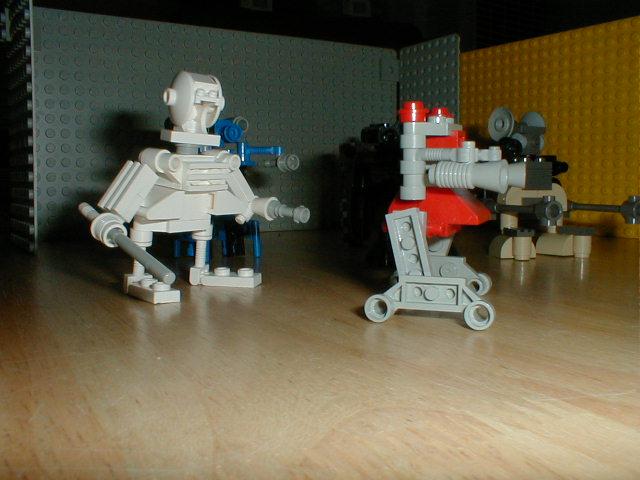 two lego robots standing on top of a wooden table