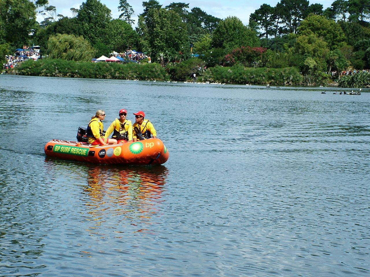 group of people in life vests rafting on water