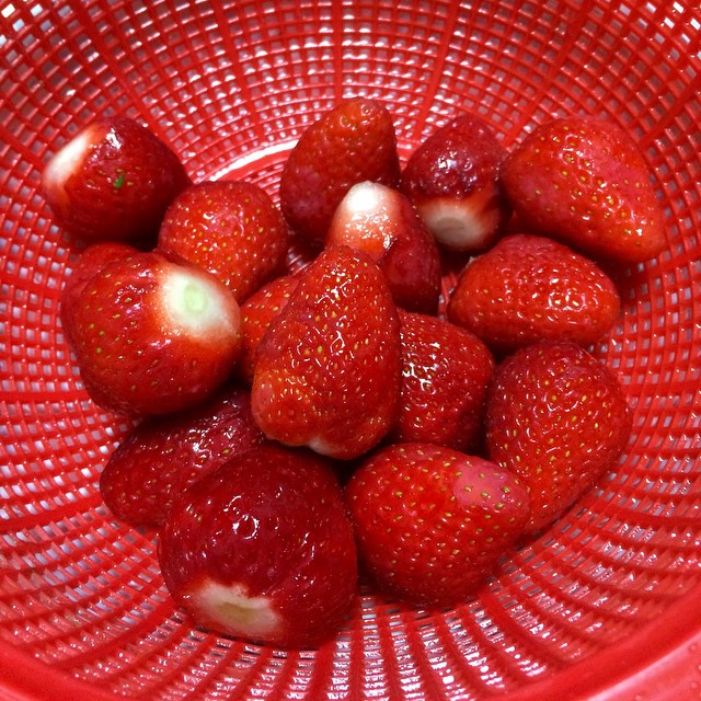 a large bowl full of red strawberries on a counter