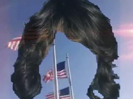 a giant hairy gorilla hangs over flags on a sunny day