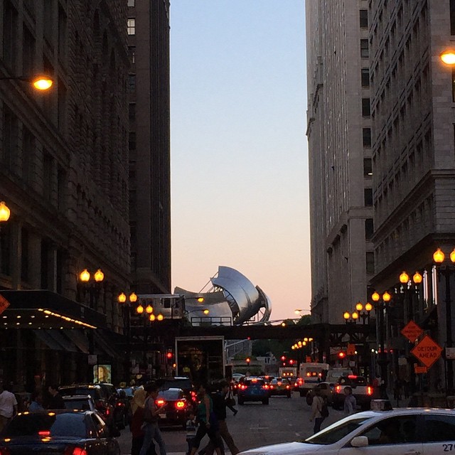 an intersection with traffic, some cars and a building in the background