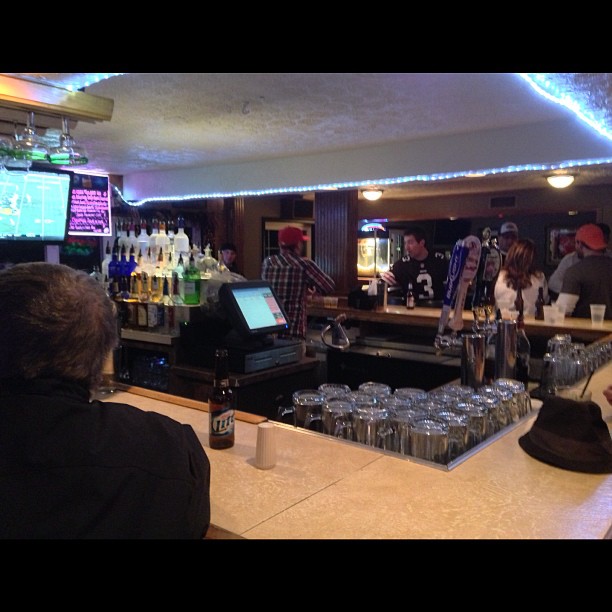 bar full of people watching on tv in a large room