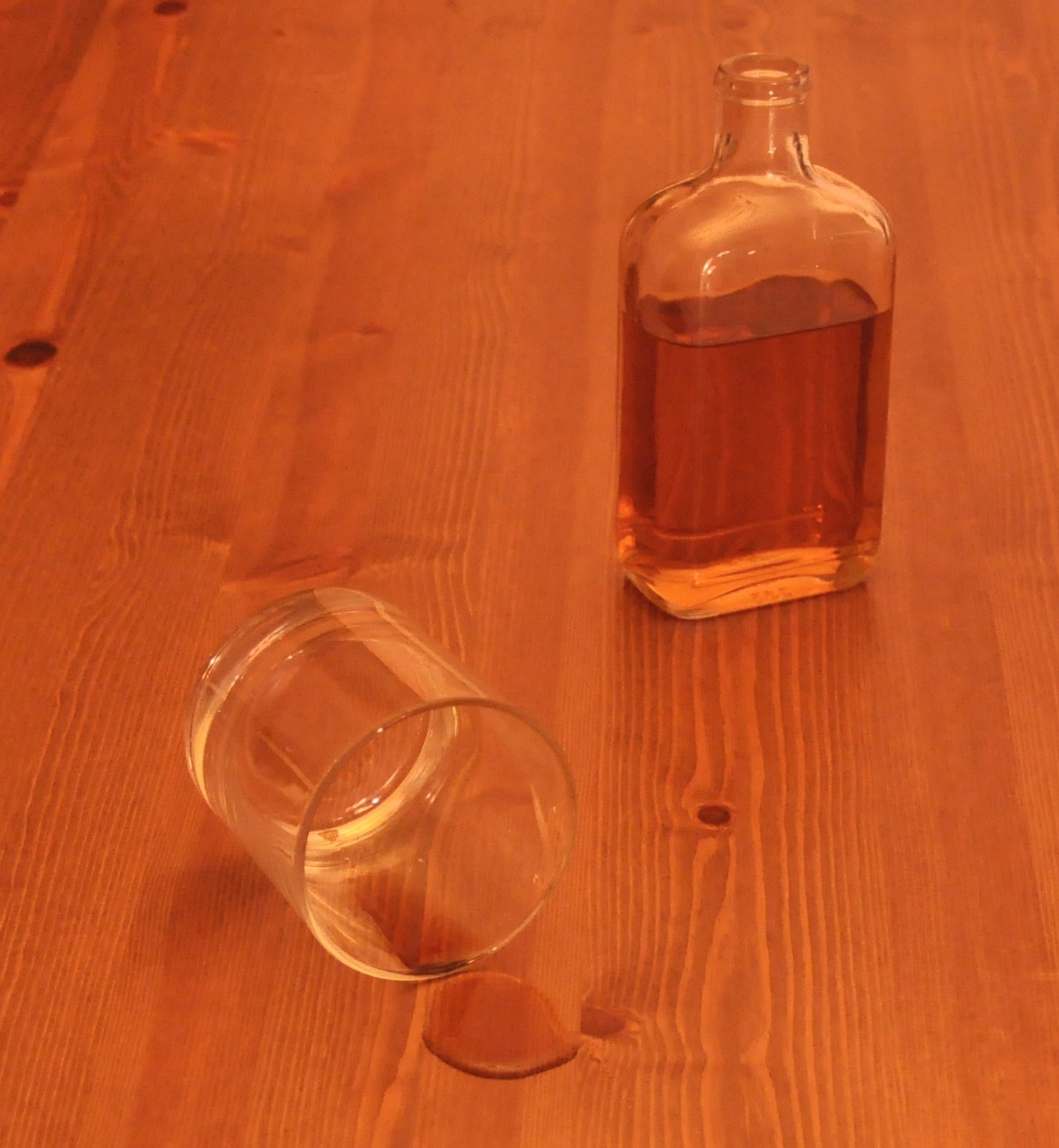 a bottle and glass on a wooden table