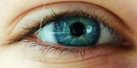 an extreme close up of a persons blue eye