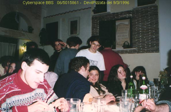a group of people sitting at a table with bottles and glasses
