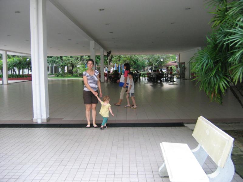 the woman is holding the child's hand while they are walking through the lobby