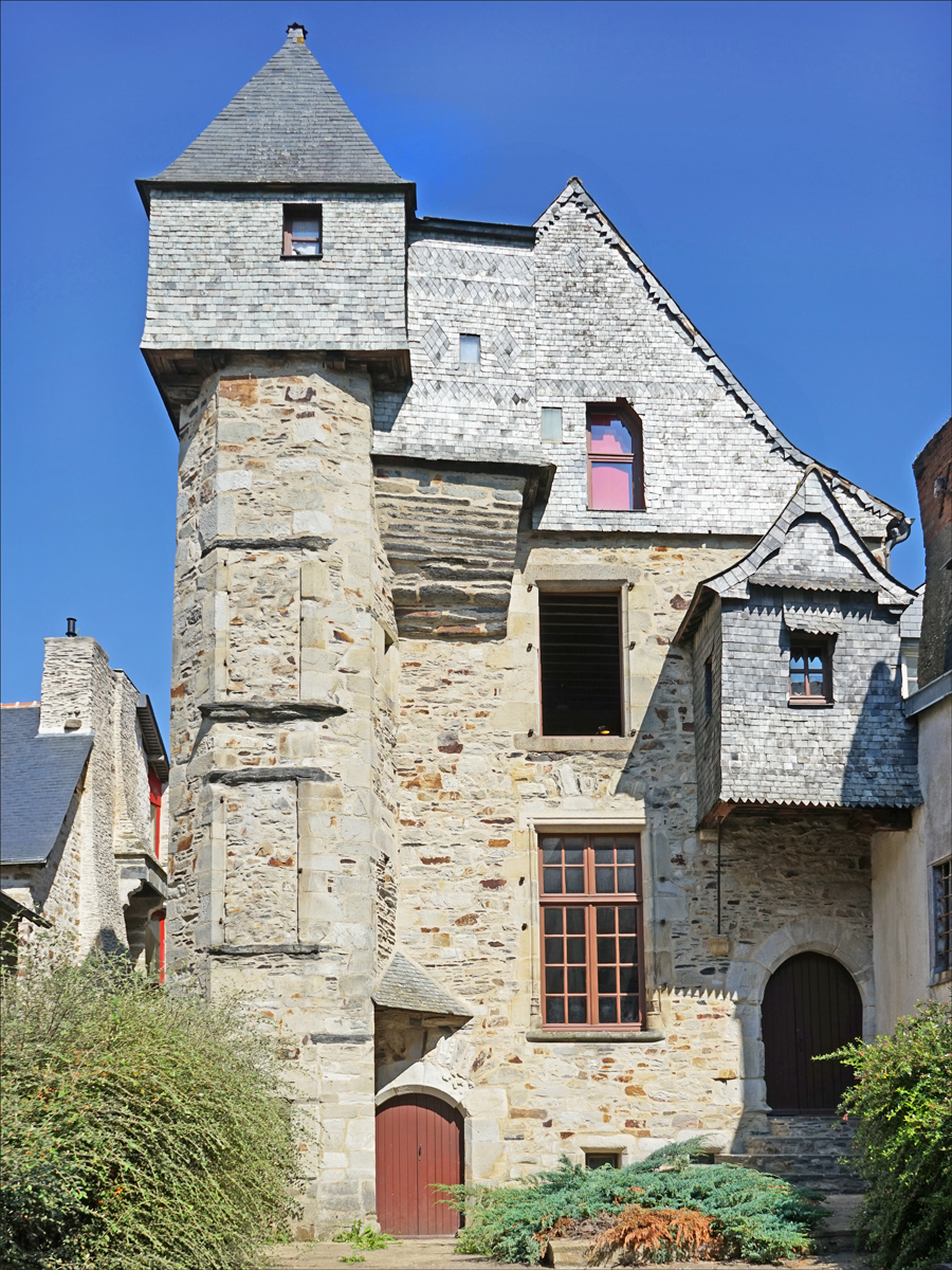 a castle style building has red shutters and windows