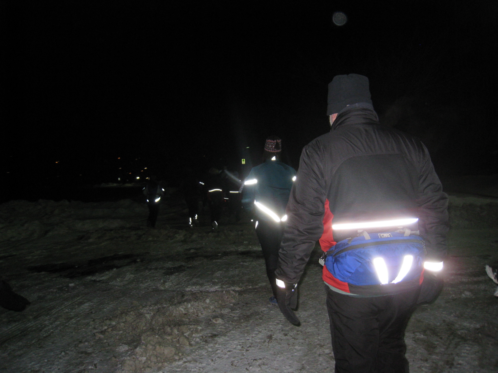 two men are running towards soing outside at night