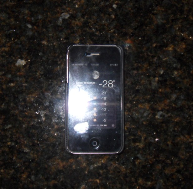 an iphone is laying on a table, showing the time