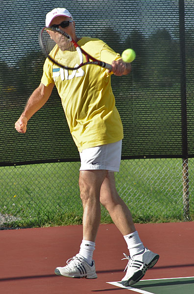 a man holding a tennis racquet on a tennis court