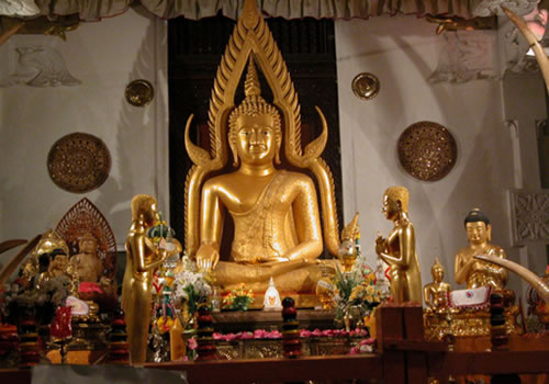 gold statues are in front of a large buddha