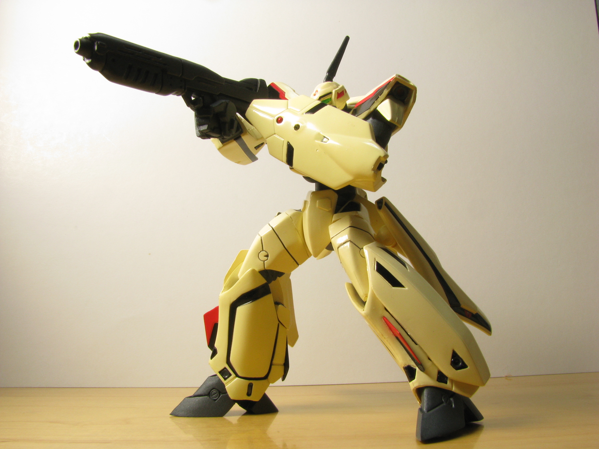 a toy robot holding a gun in one hand and wearing yellow skin