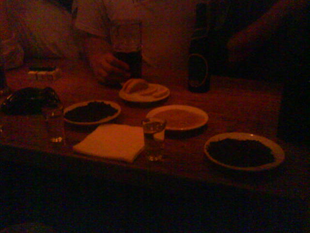 a couple of men standing around a table with plates and glasses