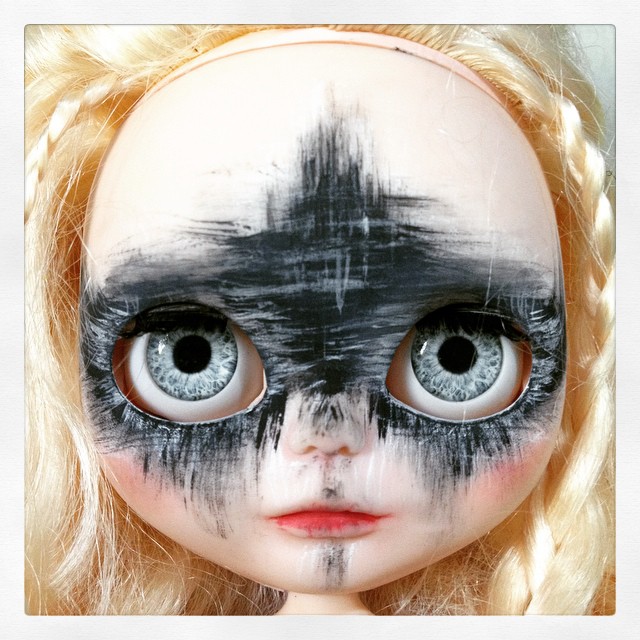 a doll is painted black and white with a feather