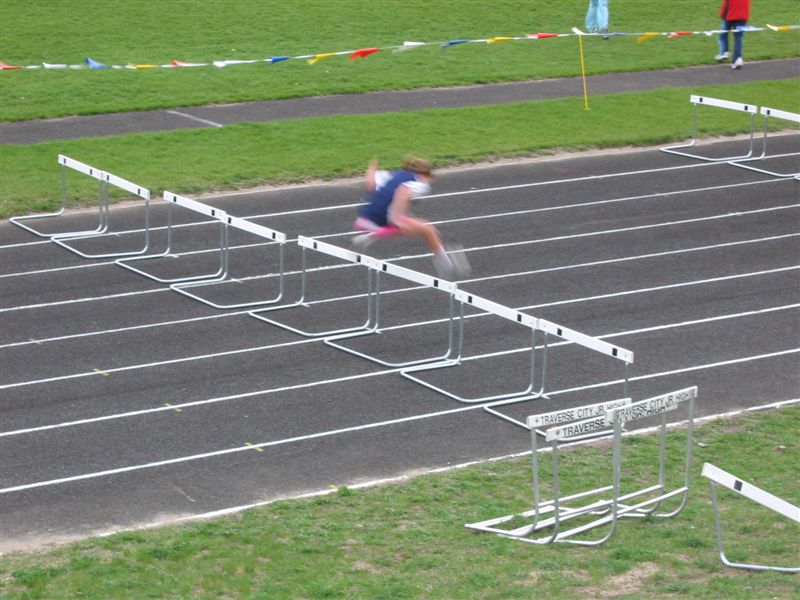 woman in the middle of hurdle for a large race