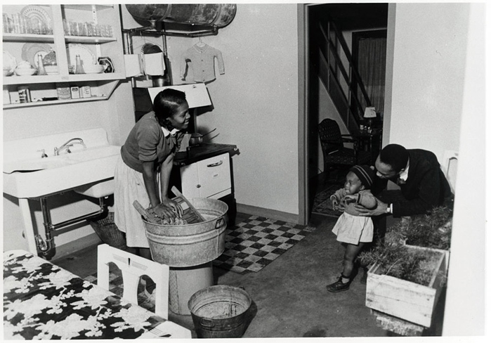 two children are playing in a small kitchen