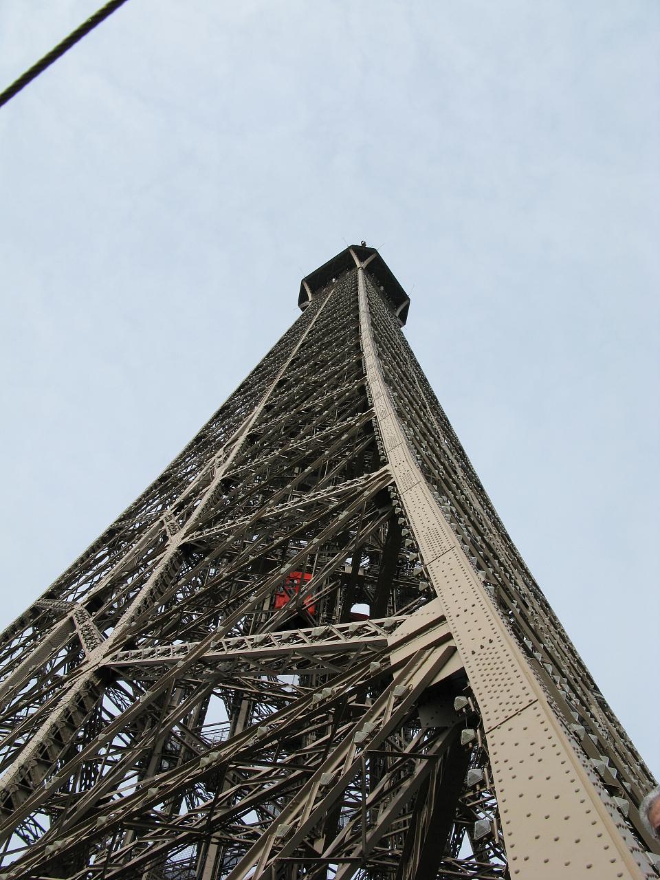 an upward view of the eiffel tower against a blue sky