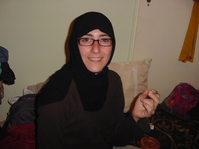 a woman is dressed in hijab and has a cigarette in her hand