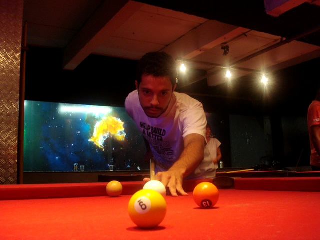 man leaning over with a pool ball in hand