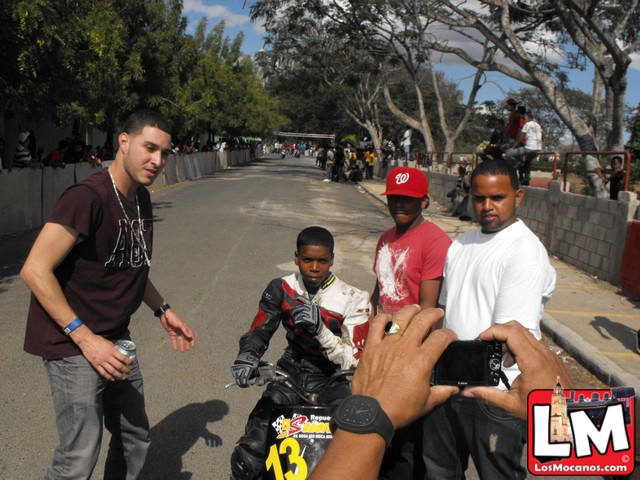 the man is being handed a skateboard by two young men