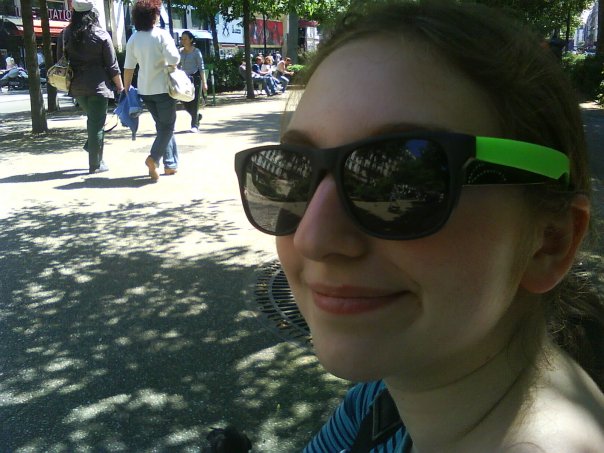 a woman with sunglasses wearing green straps in the sun