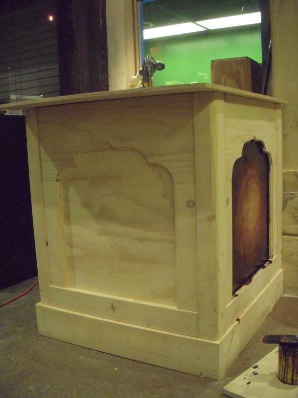 a wooden table with a window and stool in the background