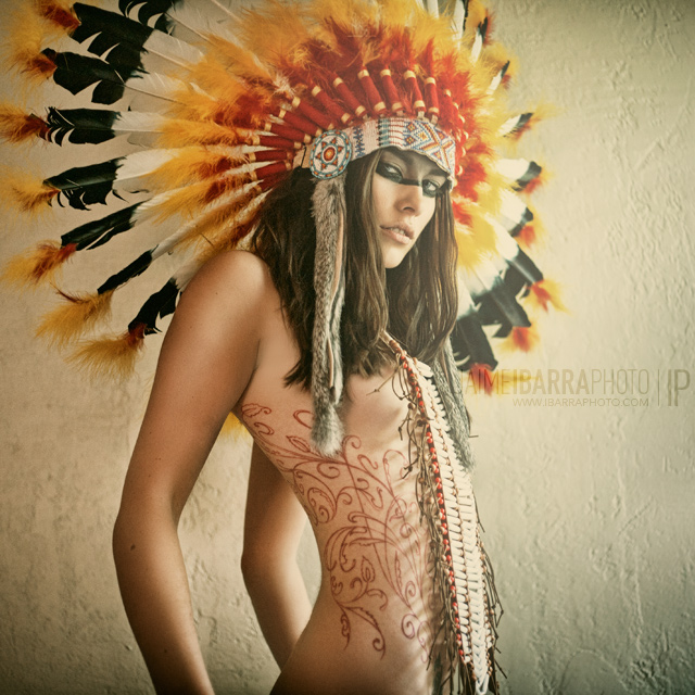 a woman wearing an elaborate headdress with feathers on her head