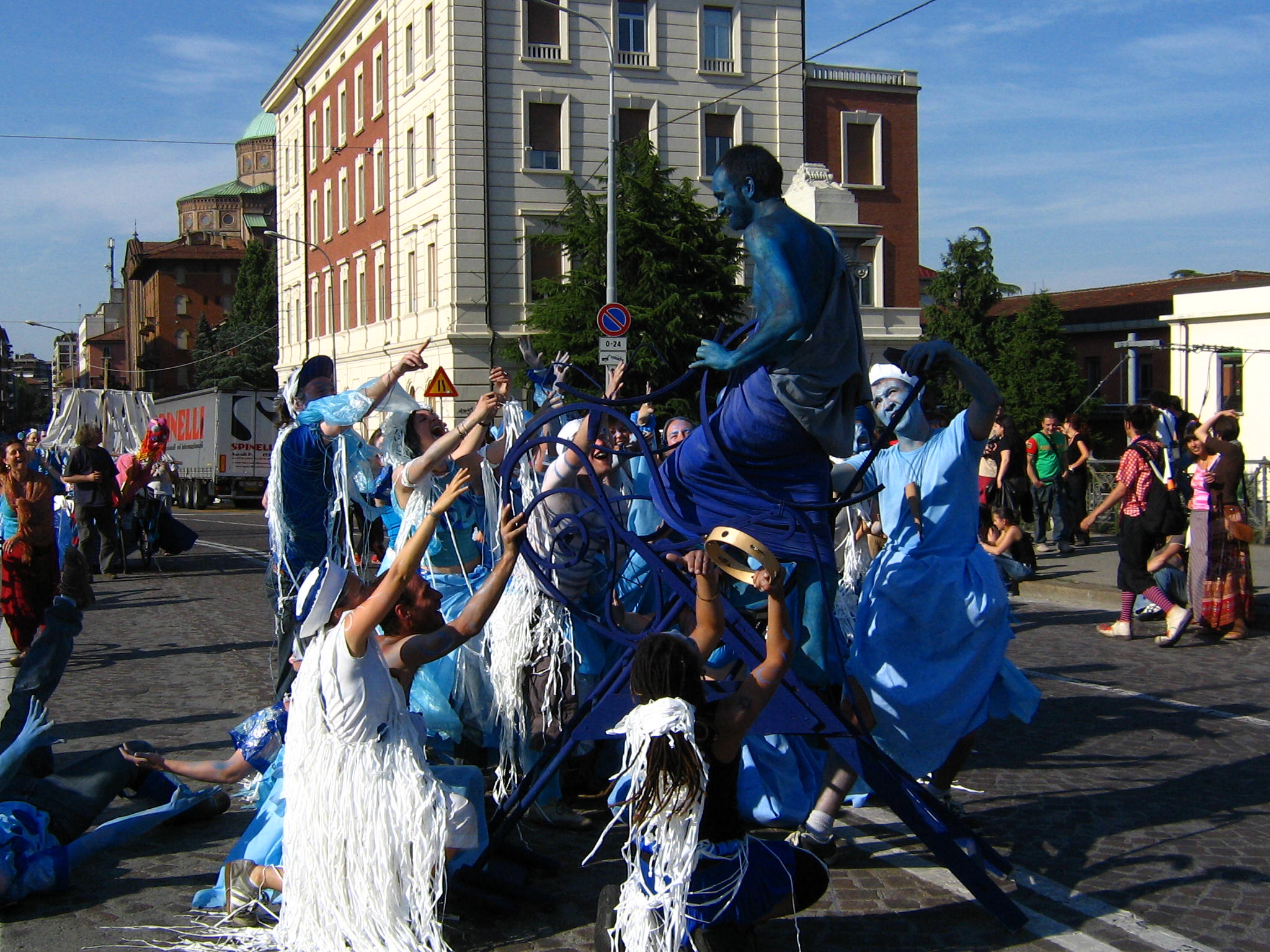 some people are dressed in blue costumes and holding onto a statue