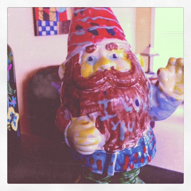 this is a plastic gnome in front of a mirror