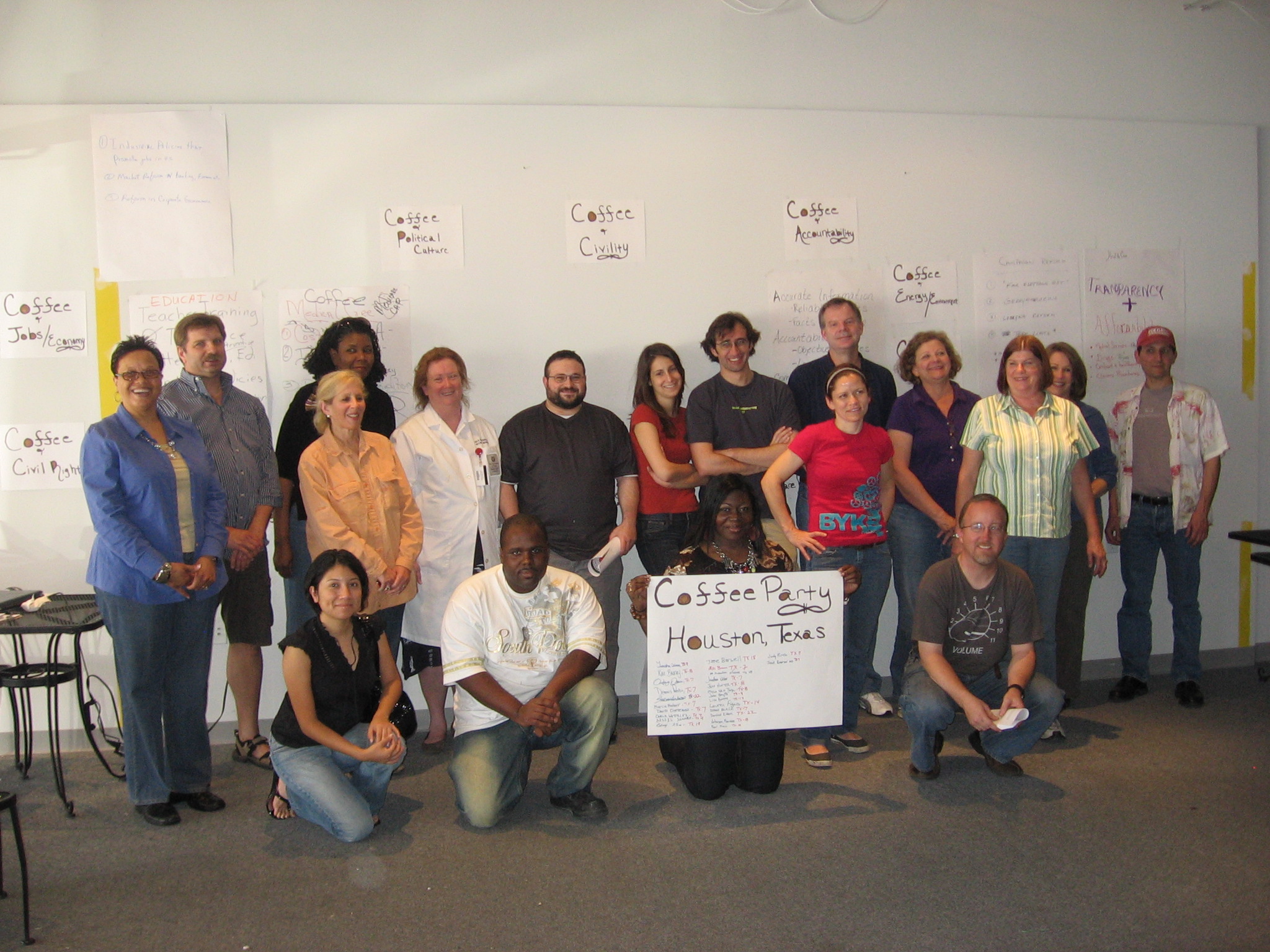 a group of people standing next to each other with a big white board