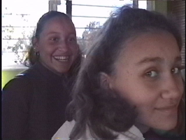 two ladies are smiling, the one with the woman's face blurry