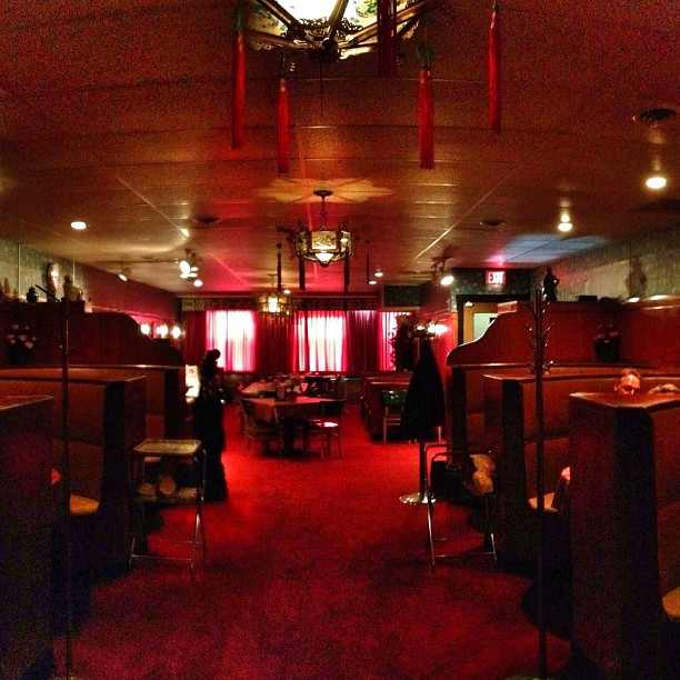 a long room with tables and chairs with a red carpet