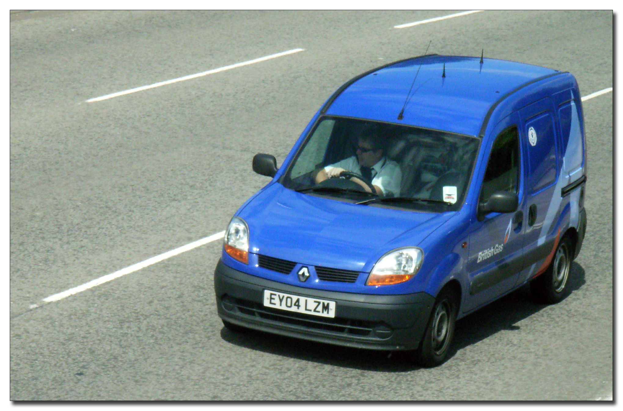 a blue van is driving down the road